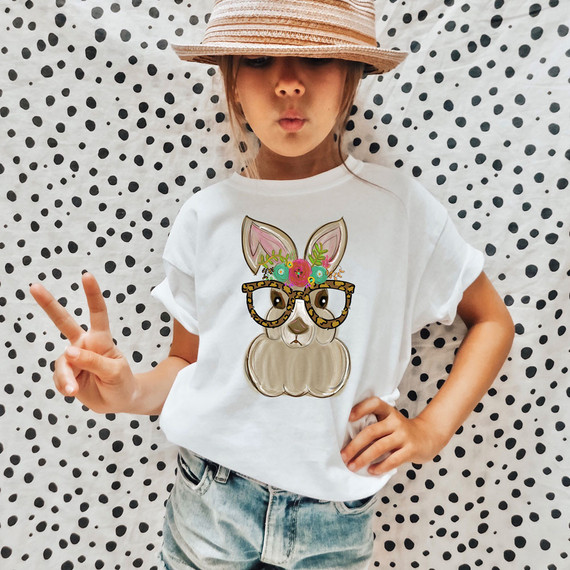 Bunny With Leopard Glasses Easter DTF Heat Transfer, colorful bunny graphic with leopard print glasses and floral accents on a white t-shirt worn by a girl.