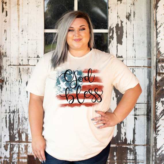 God Bless Flag DTF Heat Transfer, a woman wearing a T-shirt with a patriotic American flag and the words 'God Bless' printed on it.
