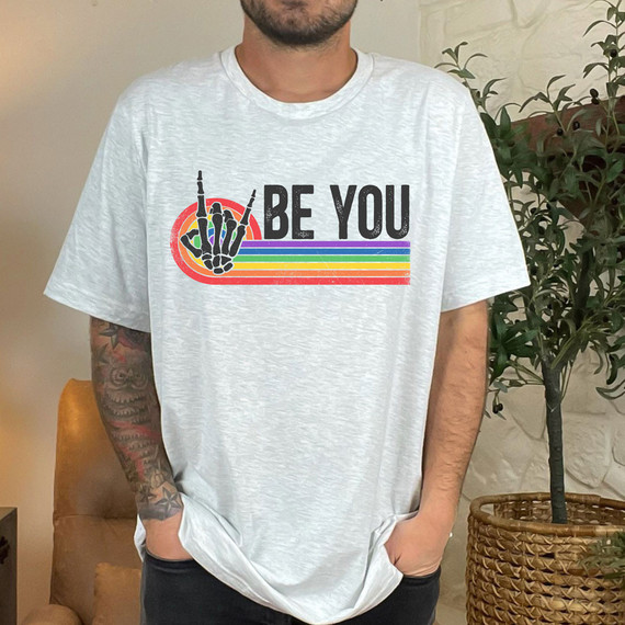 Be You Pride DTF Heat Transfer, a colorful rainbow striped design with a skeleton hand making a peace sign and the text 'BE YOU' on a white t-shirt.