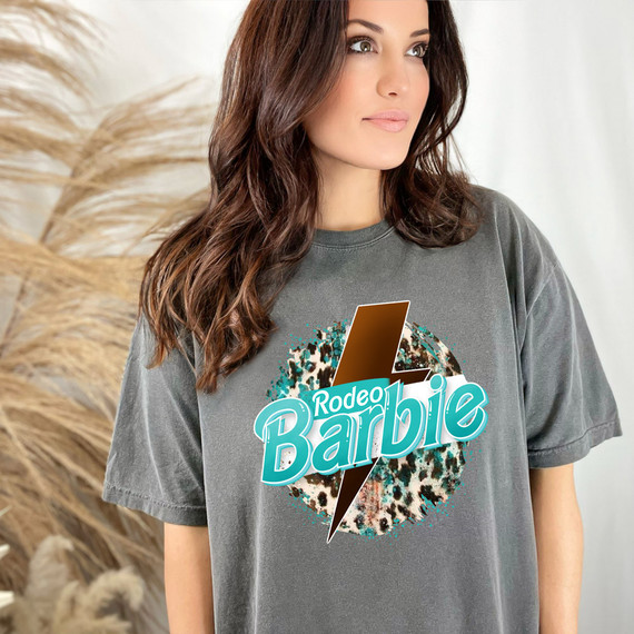 Rodeo Doll Teal DTF Heat Transfer, teal and brown graphic design with leopard print and lightning bolt on a woman's gray t-shirt.
