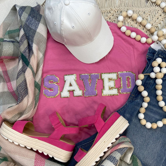 Chenille Embroidered Patch SAVED, decorative letter patch with purple and white colors and gold borders, displayed with casual fashion accessories including pink sandals, a white cap, a pink t-shirt, denim jeans, and a beaded necklace.