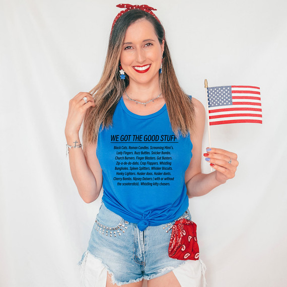 We Got The Good Stuff DTF Heat Transfer, woman wearing a blue tank top with text, holding an American flag, patriotic fashion style.