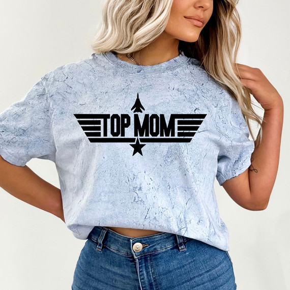 Top Mom DTF Heat Transfer, black graphic design featuring the text "Top Mom" with wing and star motifs on a light blue, textured t-shirt.