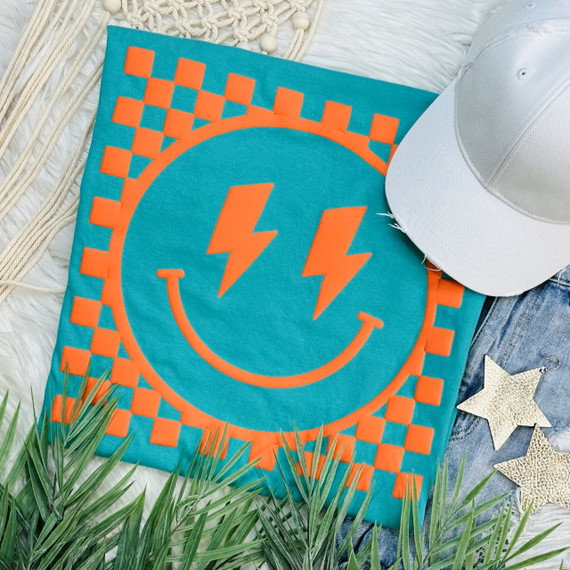 Checkered Happy Face ORANGE PUFF Screen Print Heat Transfer, orange and teal fabric with a smiling face design featuring lightning bolt eyes.