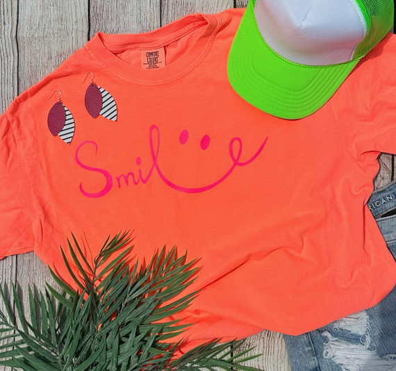 Smile NEON Pink Screen Print Heat Transfer, vibrant neon pink smiley face design on a bright orange t-shirt.