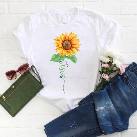 Jesus Watercolor Sunflower Sublimation Transfer, a vibrant illustration of a sunflower with the word 'Jesus' vertically written beneath it, printed on a white T-shirt.