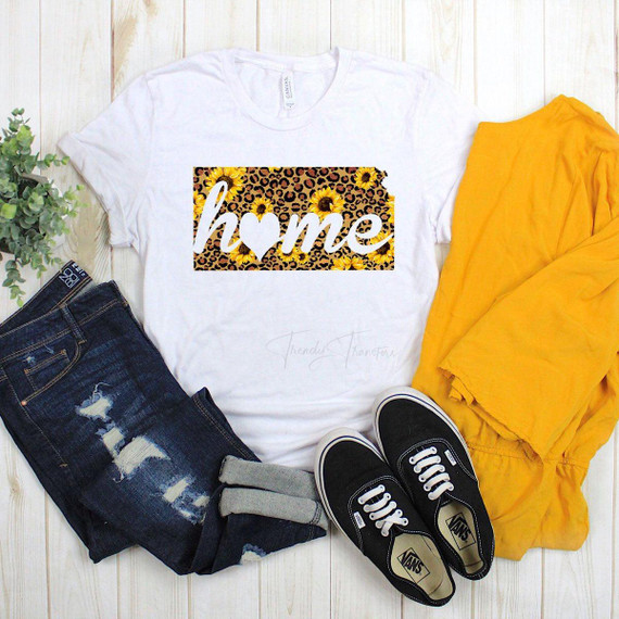 Kansas Home Leopard and Sunflower Sublimation Transfer, white t-shirt with a leopard print background, yellow sunflowers, and the word 'home' with a heart-shaped 'o'.