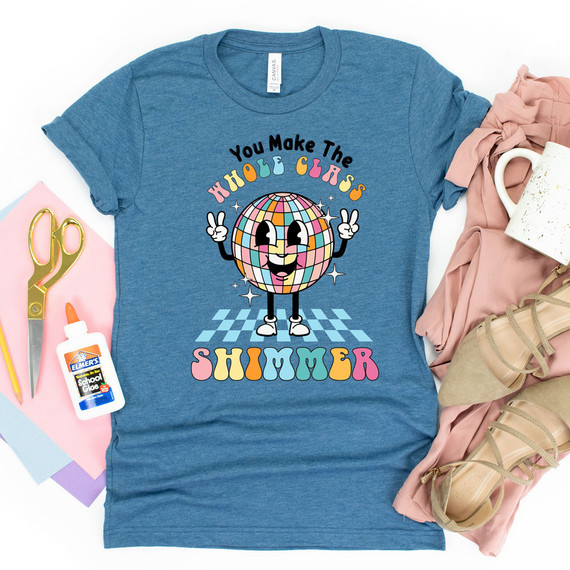 You Make The Whole Class Shimmer DTF Heat Transfer, colorful and playful design on a blue t-shirt showing a disco ball character with a happy face.