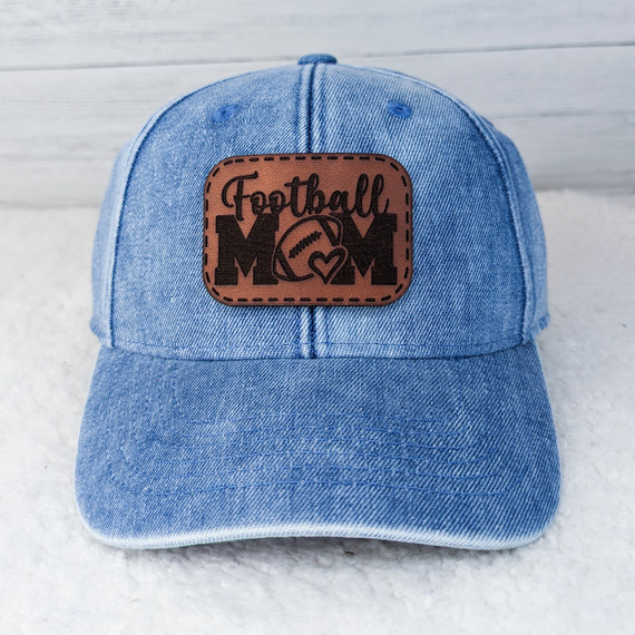 Football Mom Leather Hat Patch, denim baseball cap with a brown leather patch featuring the words 'Football Mom', a football graphic, and a heart design.