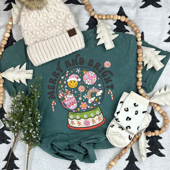 Merry And Bright Retro Snow Globe DTF Heat Transfer, a colorful holiday-themed snow globe design on a dark green t-shirt.