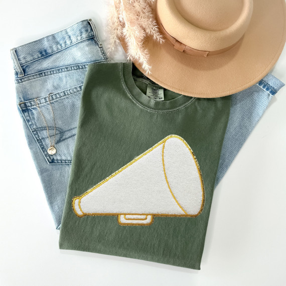 Megaphone Chenille Patch, white and yellow embroidered patch in the shape of a megaphone on a green t-shirt.