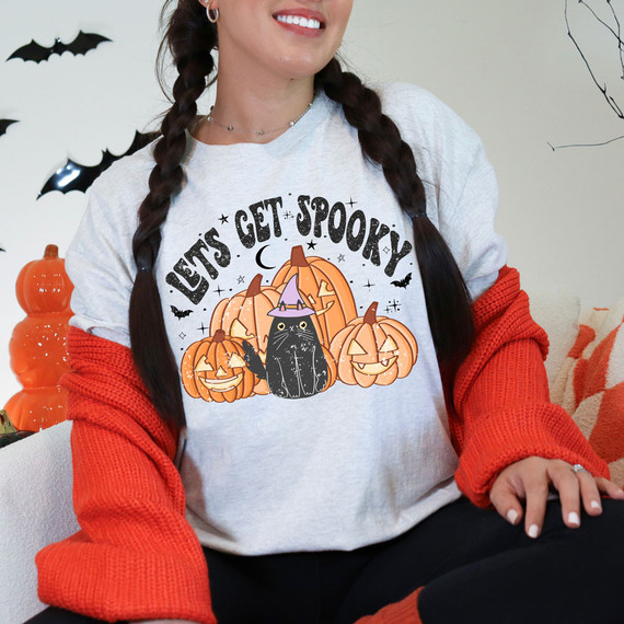 Let's Get Spooky DTF Heat Transfer, Halloween pumpkin and black cat design on a woman's t-shirt.