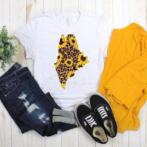 Maine Leopard Sunflower Sublimation Transfer, white T-shirt with a sunflower and leopard print map of Maine design, paired with ripped jeans, yellow jacket, and black sneakers.
