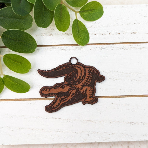 Gator Mascot Leather Keychain, a detailed brown leather keychain in the shape of a gator mascot with a small metal loop at the top for attaching keys.