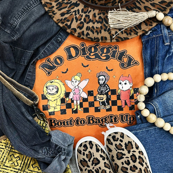 No Diggity Bout To Bag It Up DTF Heat Transfer product, vibrant orange t-shirt with cartoon Halloween characters and text, displayed with denim jacket, leopard print shoes, and a beaded necklace.
