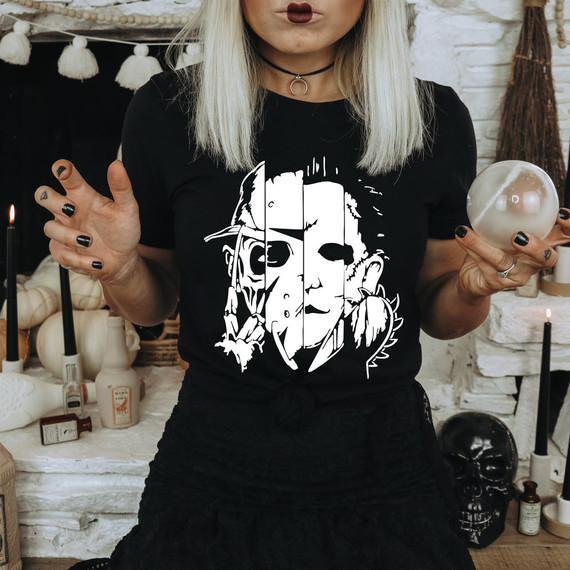 Horror Mask WHITE DTF Heat Transfer, white horror mask graphic on a black T-shirt worn by a woman with platinum blonde hair, holding a sphere and posing indoors.