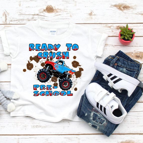 Back To School Monster Truck Crush Pre School sublimation transfer T-shirt, featuring a colorful monster truck with a flame design on a white fabric, surrounded by dirt splashes.