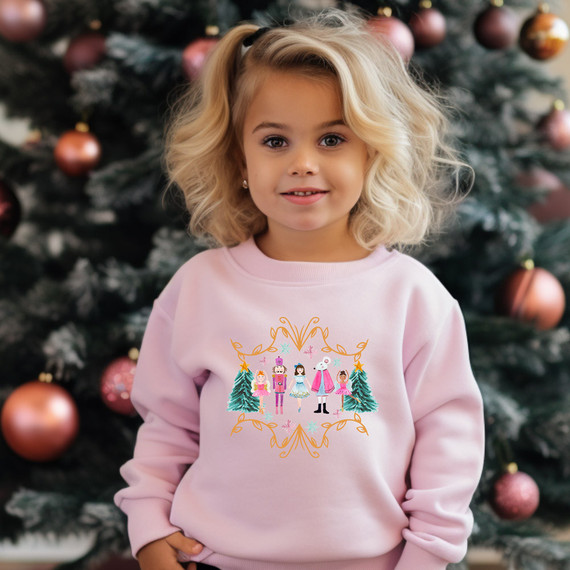 Pink Nutcracker DTF Heat Transfer, image of a girl wearing a pink sweatshirt with Nutcracker and Christmas tree design.