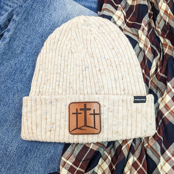 Triple Cross Leather Hat Patch, beige knit beanie hat with brown leather patch featuring three crosses and a mountain design.