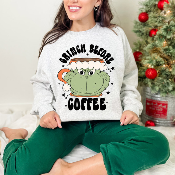 Green Guy Before Coffee DTF Heat Transfer, humorous cartoon of a grumpy green creature in a coffee mug with a Santa hat, Christmas tree in the background.