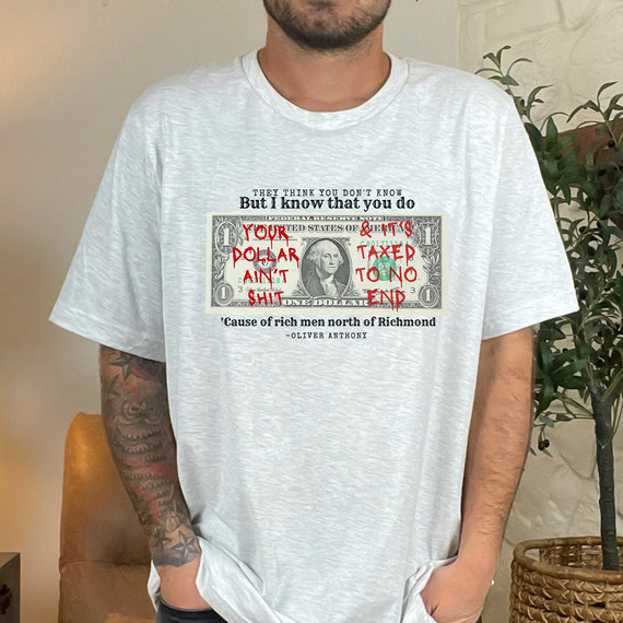 Your Dollar Ain't Shit DTF Heat Transfer, T-shirt with a dollar bill graphic and red handwritten style text overlay.