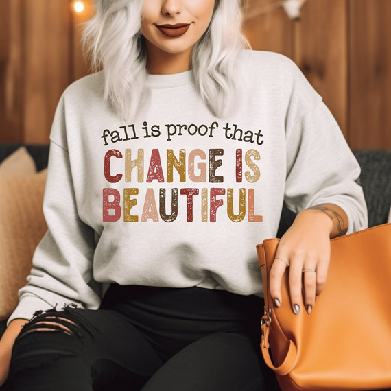 Fall Is Proof That Change Is Beautiful, product featuring a woman wearing a sweatshirt with a colorful text design that says 'fall is proof that change is beautiful' for DTF heat transfer.
