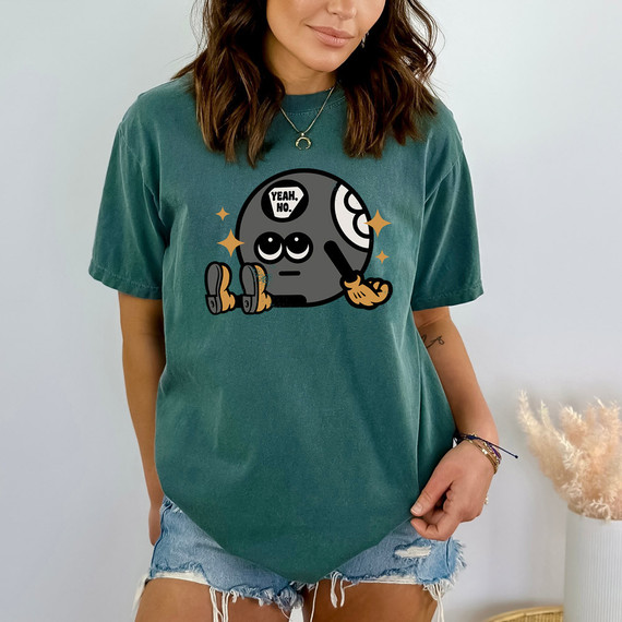 Yeah No. Magic 8 Ball DTF Heat Transfer, cartoon-style design of a new moon with a face, wearing boots, holding a paintbrush, with a speech bubble saying 'Yeah. No.' and shiny stars around it, printed on a teal T-shirt.