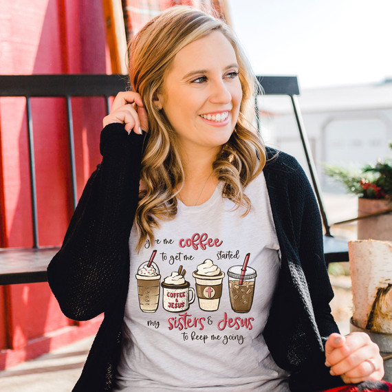 Give Me Coffee To Get Me Started DTF Heat Transfer, a woman wearing a t-shirt with illustrated coffee drinks and the text "Give me coffee to get me started my sisters & Jesus to keep me going".