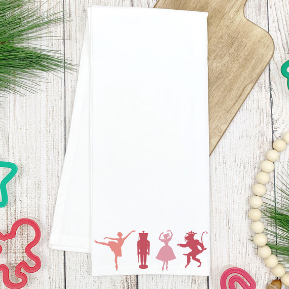 Nutcracker Dancers DTF Heat Transfer, white fabric towel with holiday-themed nutcracker dancer silhouettes at the bottom.