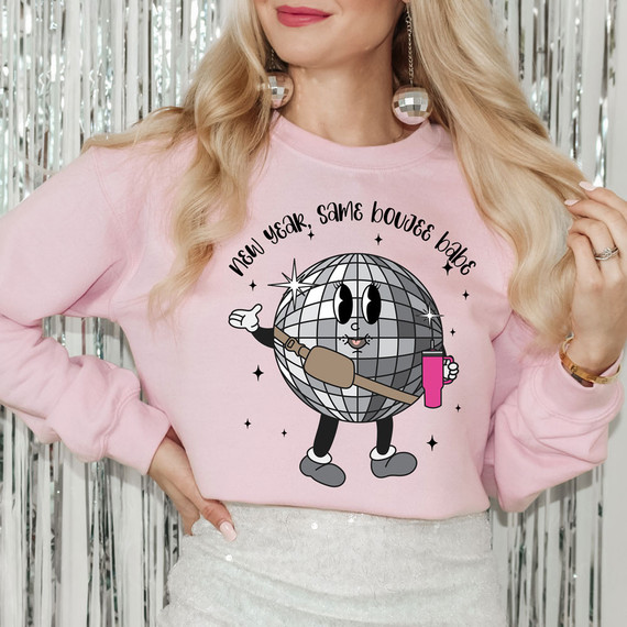 New Year Same Boujee Babe DTF Heat Transfer, a pink sweatshirt with a cartoon disco ball character holding a champagne bottle and a pink drink, surrounded by stars and the caption 'New Year Same Boujee Babe'.