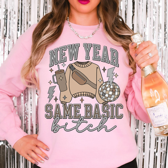 New Year Same Basic Bitch DTF Heat Transfer, a design on a pink sweatshirt featuring a sweater, drink, fanny pack, disco ball, and lightning bolt.