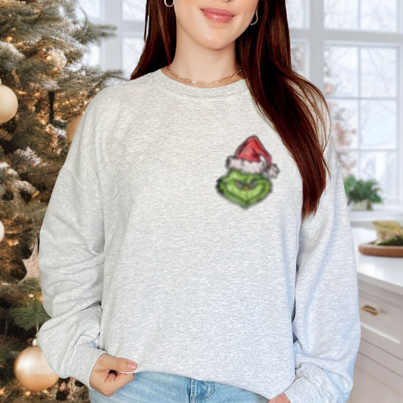 G Guy DTF Heat Transfer, Christmas-themed green cartoon character wearing a Santa hat on a light gray sweatshirt.