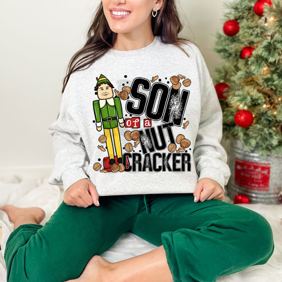 Son Of A Nutcracker DTF Heat Transfer, Christmas-themed sweatshirt with a cartoon character and festive design.