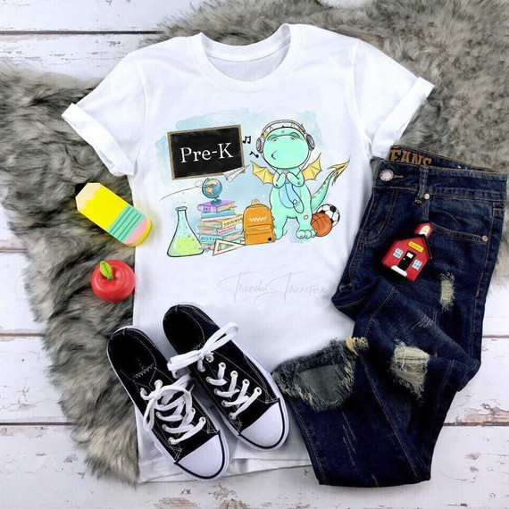 Back To School Dragon Blue Pre-K Sublimation Transfer, image of a white t-shirt with a cartoon dragon wearing headphones and surrounded by school-related items.