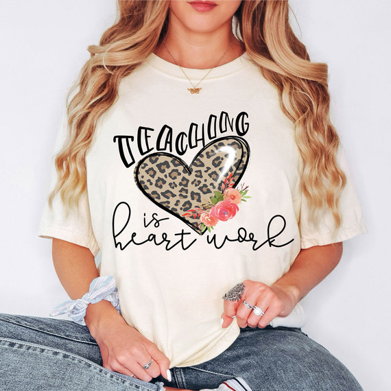 Teaching Is Heart Work DTF Heat Transfer, close-up of a woman wearing a T-shirt with a heart graphic and floral design.
