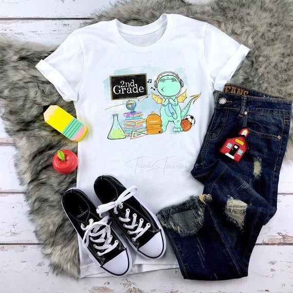 Back To School Dragon Blue Second Grade Sublimation Transfer, a children's T-shirt with a cute dragon wearing headphones and surrounded by school-related items.