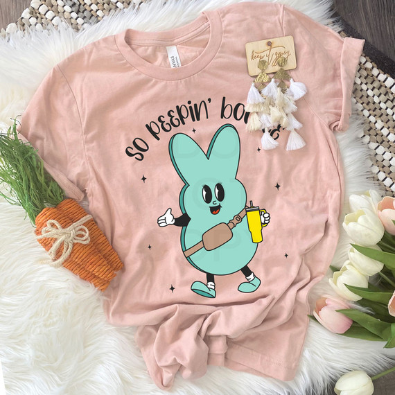 So Peepin' Boujee DTF Heat Transfer, pink t-shirt with a cute cartoon bunny holding a yellow drink and a brown bag, with the text 'so peepin' boujee' surrounding the bunny.