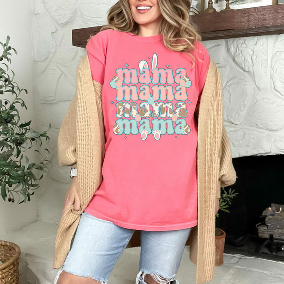 Mama Bunny Stacked DTF Heat Transfer, showcasing a pink T-shirt with a cute Mama Bunny design with layered bunny illustrations and pastel-colored eggs, worn by a smiling woman.