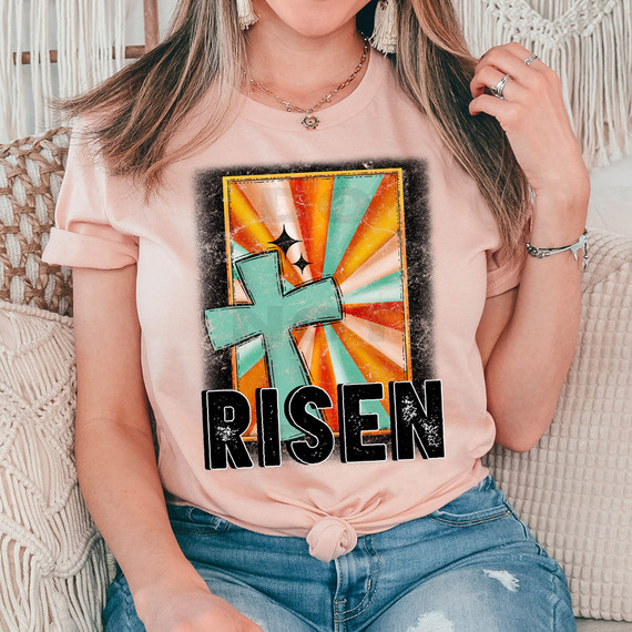 Risen DTF Heat Transfer, colorful graphic T-shirt with a large teal cross and bold black Risen text
