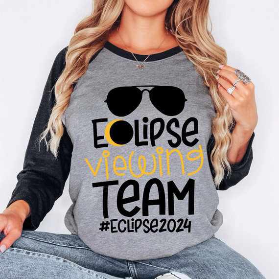 Eclipse Viewing Team DTF Heat Transfer, a woman wearing a gray and black long sleeve shirt with a sunglasses graphic and the text 'Eclipse Viewing Team #Eclipse2024' in black and yellow.