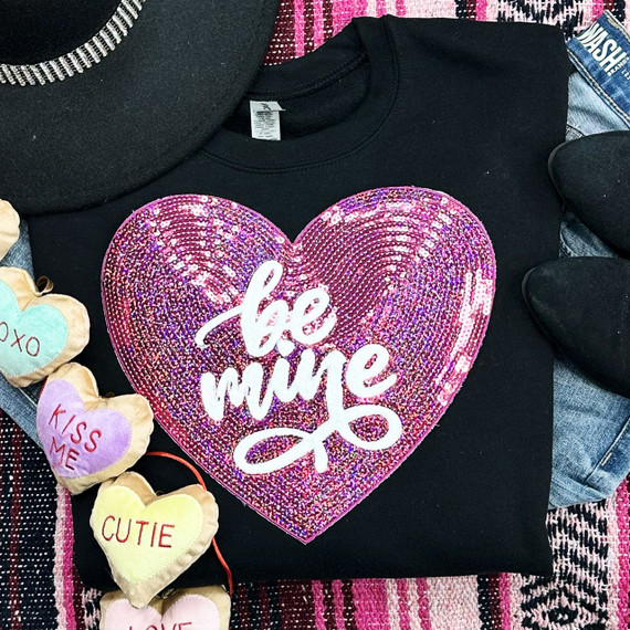 Be Mine SEQUIN HEART Patch, pink sequined heart patch with white 'be mine' lettering on a black T-shirt surrounded by small plush hearts with messages like 'XOXO', 'KISS ME', and 'CUTIE'.