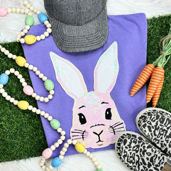 Adult White Sequin Bunny Face Patch, a white and pink sequined bunny face patch with embroidery details on a purple fabric, surrounded by colorful Easter decorations.