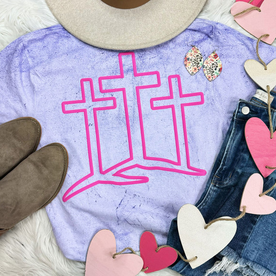 Three Crosses Pink PUFF Screen Print Heat Transfer, pink outline design of three crosses on a lavender shirt with various accessories around it.
