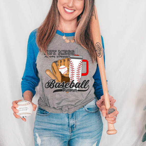 Hot Mess Always Stressed Baseball Mama DTF Heat Transfer, woman wearing a baseball-themed shirt with a baseball, glove, and bat illustration, holding a baseball and a bat, smiling.