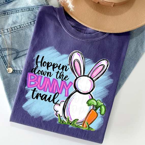 Hoppin' Down The Bunny Trail DTF Heat Transfer, colorful design with bunny, carrot, and text on purple T-shirt.