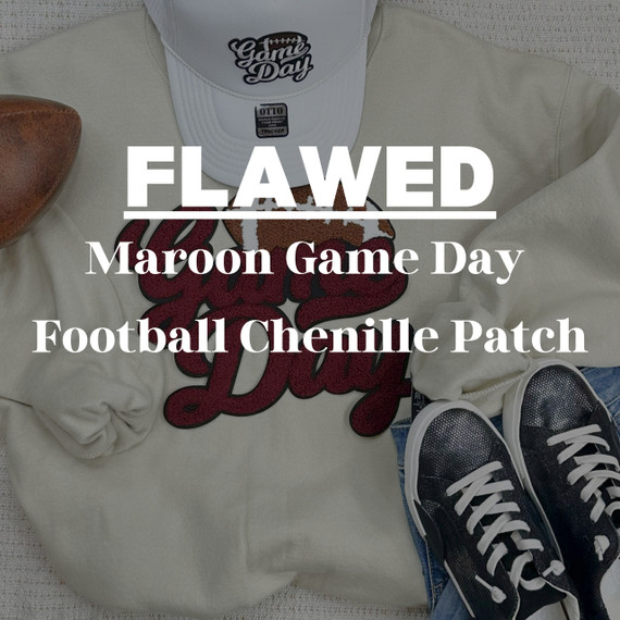FLAWED Maroon Game Day Football Chenille Patch, close-up of a maroon foam chenille football patch with red and white embroidery on a beige sweatshirt, with a white cap and black sneakers nearby.