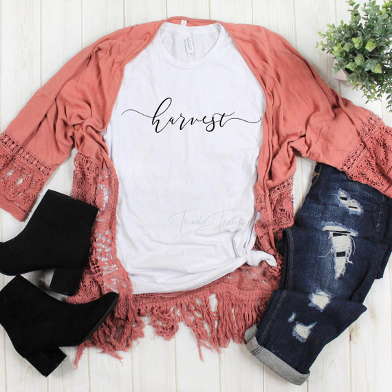 Harvest Cursive Sublimation Transfer on a white t-shirt, with a pink lace cardigan, ripped jeans, and black boots.