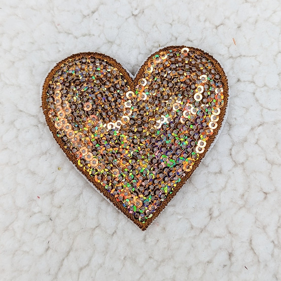 BRONZE sequin heart HAT/POCKET Patch, decorative heart-shaped patch covered with bronze sequins on a marble surface.