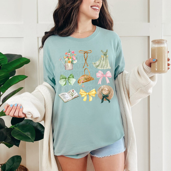 Cottage Core Collage DTF Heat Transfer, close-up of a woman's torso wearing a pastel blue T-shirt with colorful cottage core-themed illustrations and details.