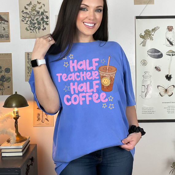 Half Teacher Half Coffee DTF Heat Transfer, woman modeling a blue t-shirt with a graphic of a coffee cup and colorful text.